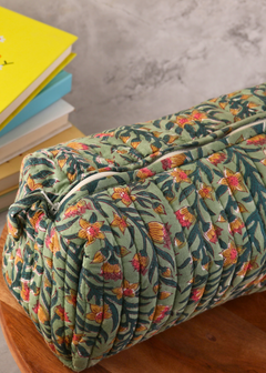 Block printed green toiletry bag on wooden surface