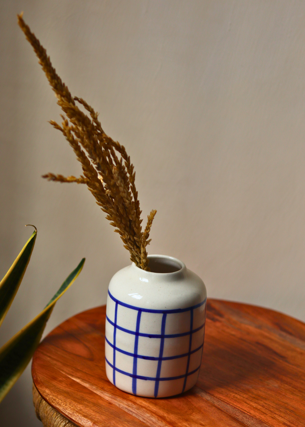 Chequered blue vase on wooden surface