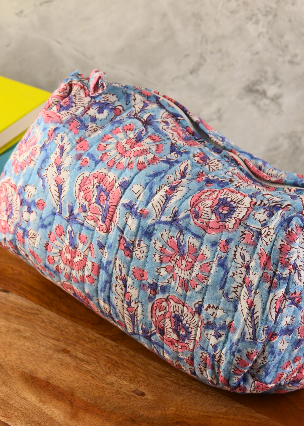 Medium size block printed toiletry bag on a wooden surface