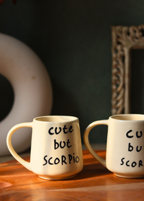 Cute but scorpio coffee mug on wooden surface