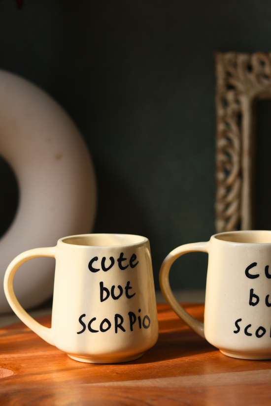 Cute but scorpio coffee mug on wooden surface