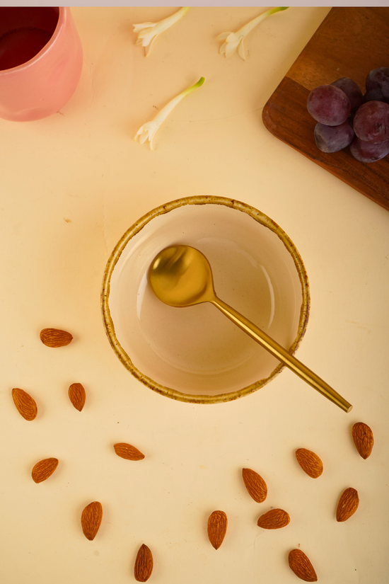 Ivory stoneware bowl with golden cutlery 