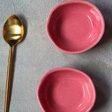 Two pink nut bowls with cutlery
