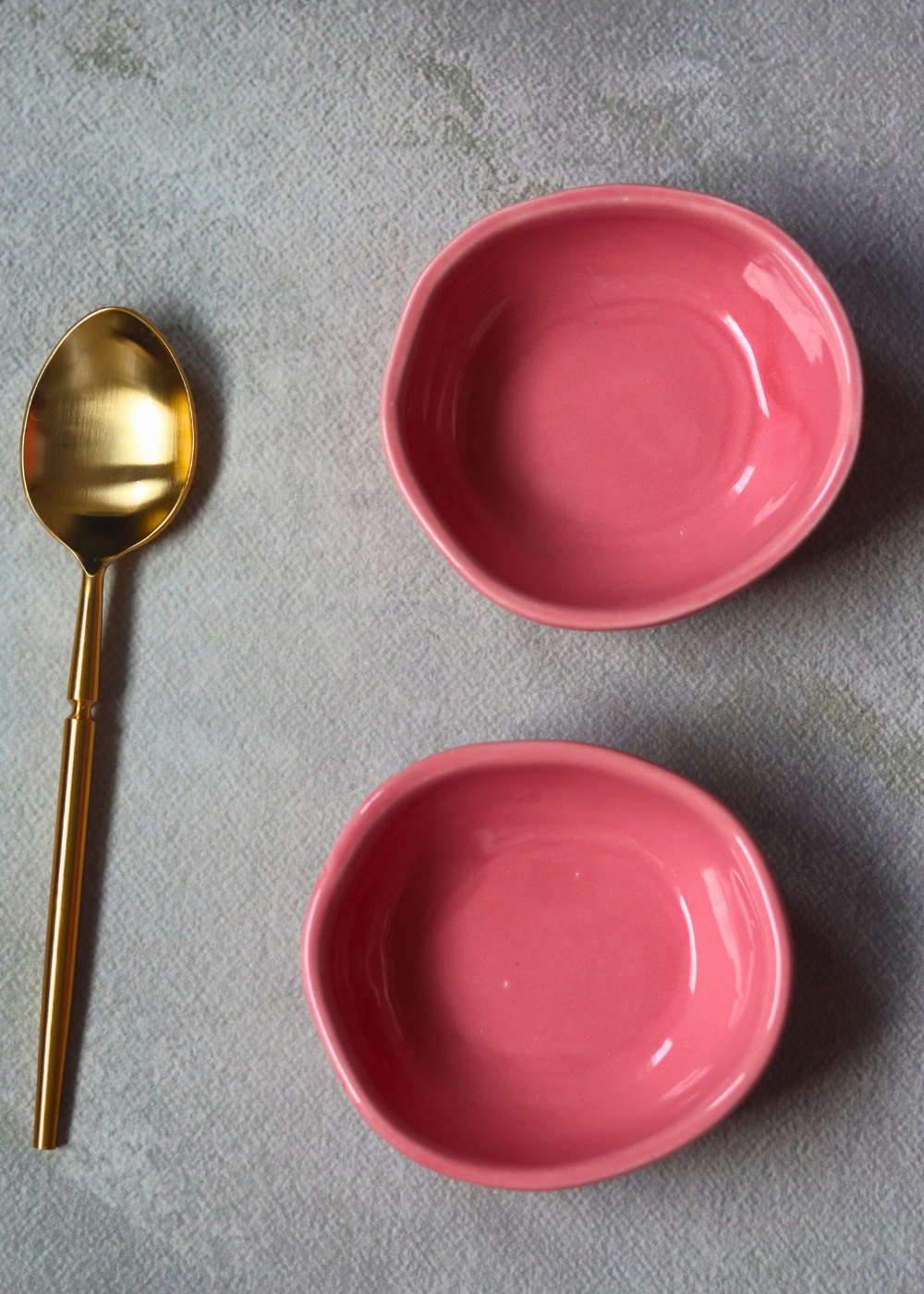 Two pink nut bowls with cutlery