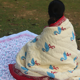 A girl draping a quilt in garden