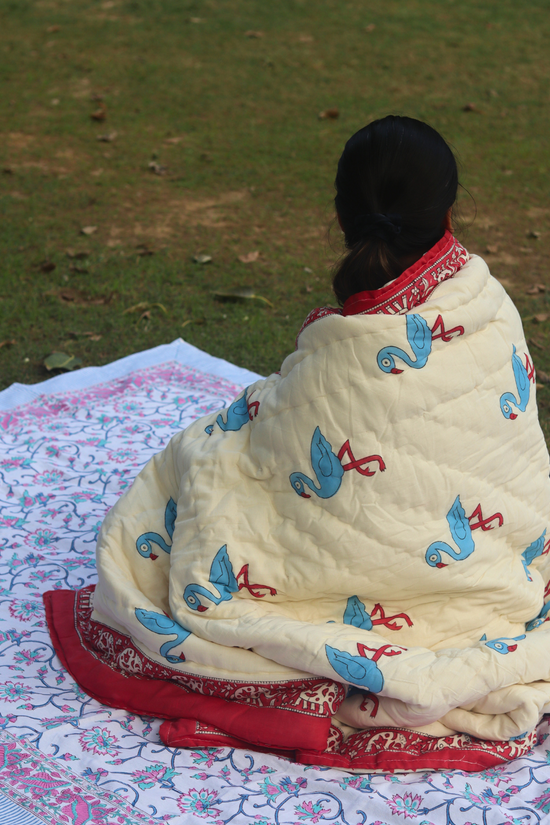 A girl draping a quilt in garden