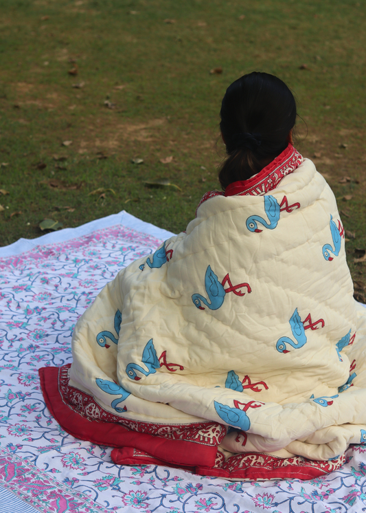 A girl draping a quilt in garden
