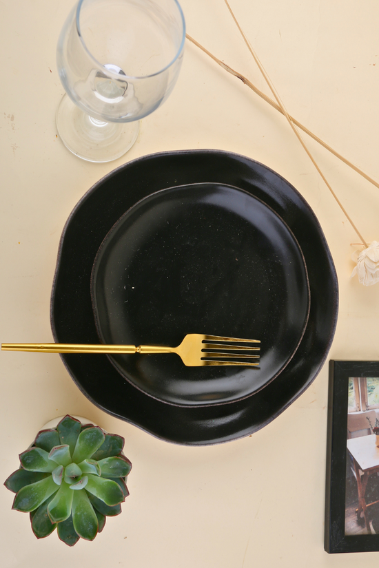 Golden fork on black plate