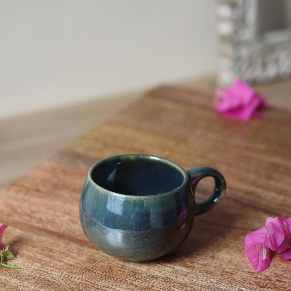 Green chai cup on wooden surface