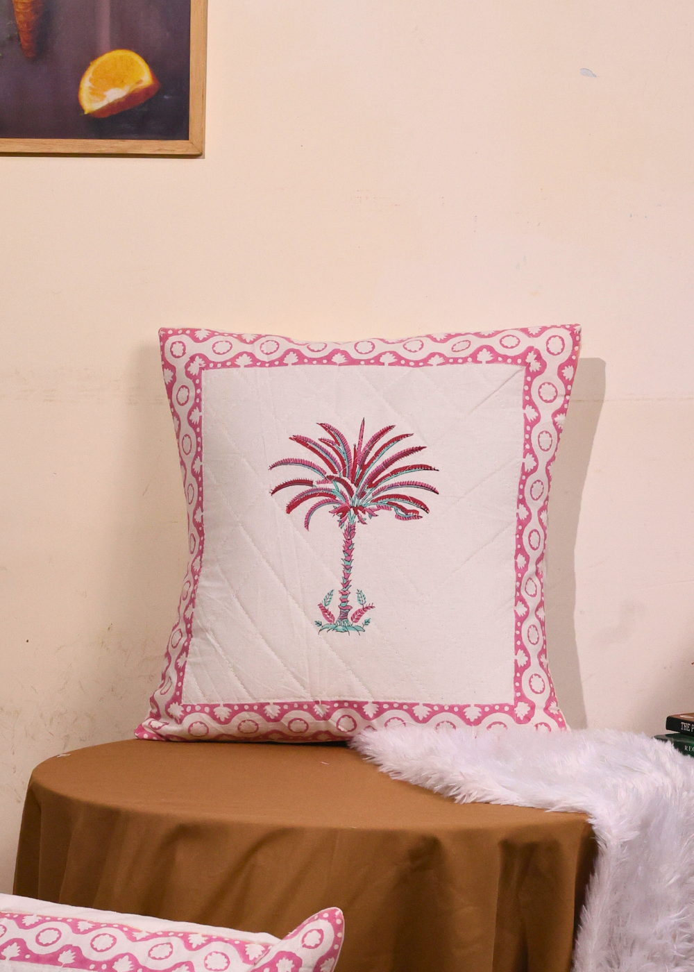 Pink and white cushion cover with palm print on it