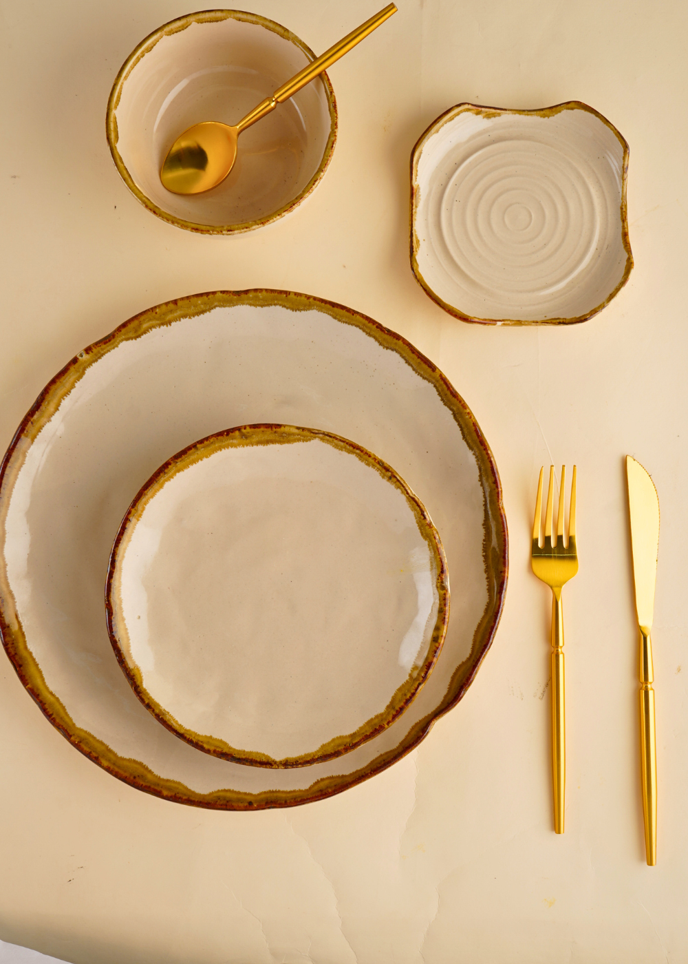 ivory stoneware dinner set with golden cutlery