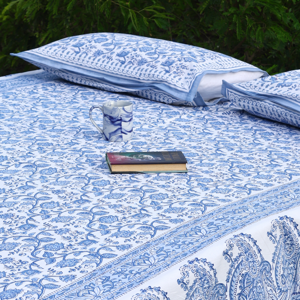 Blue bedsheet with pillows and books on garden