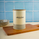 White & black coffee jar on wooden surface