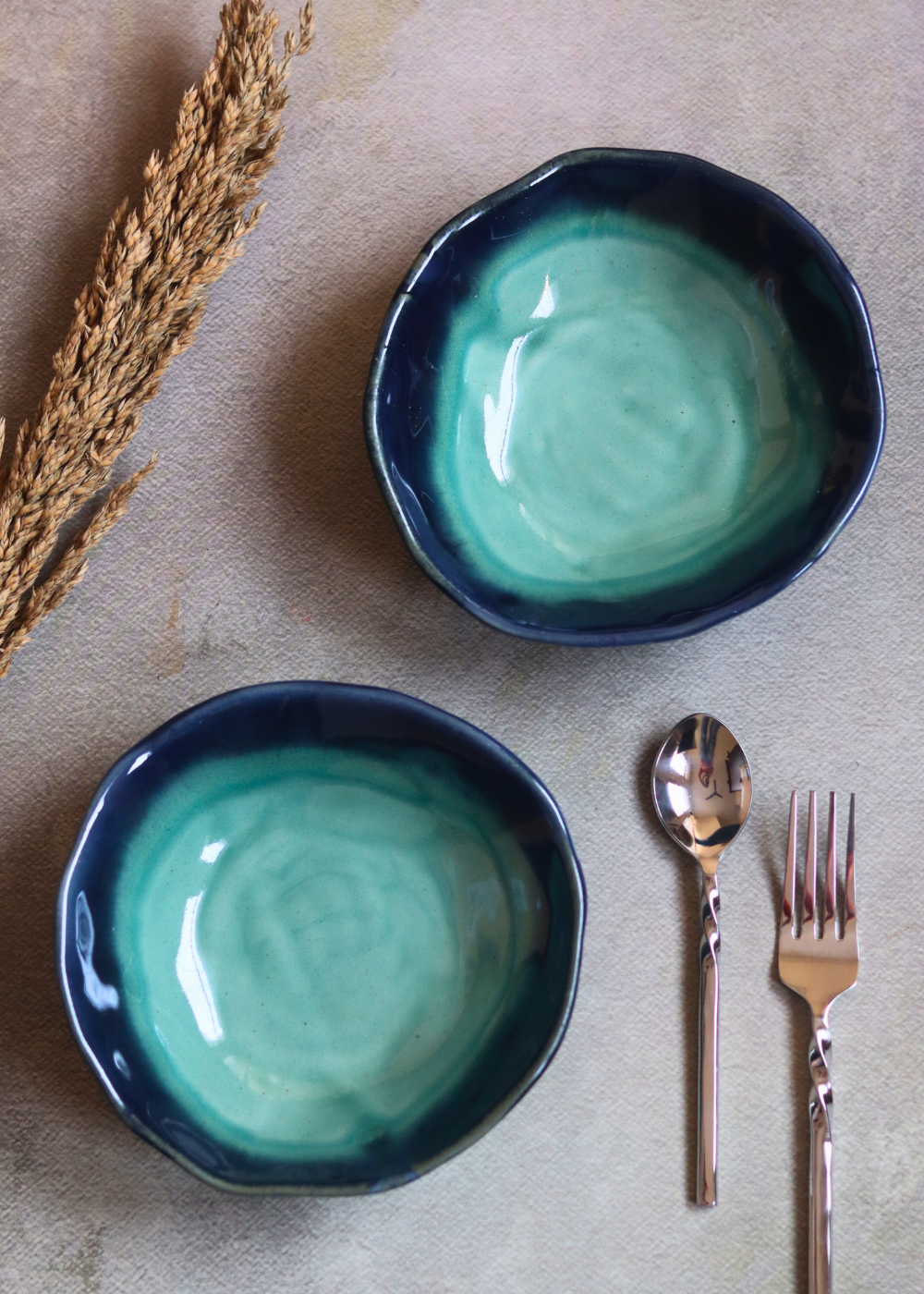Two ceramic teal bowls with cutleries