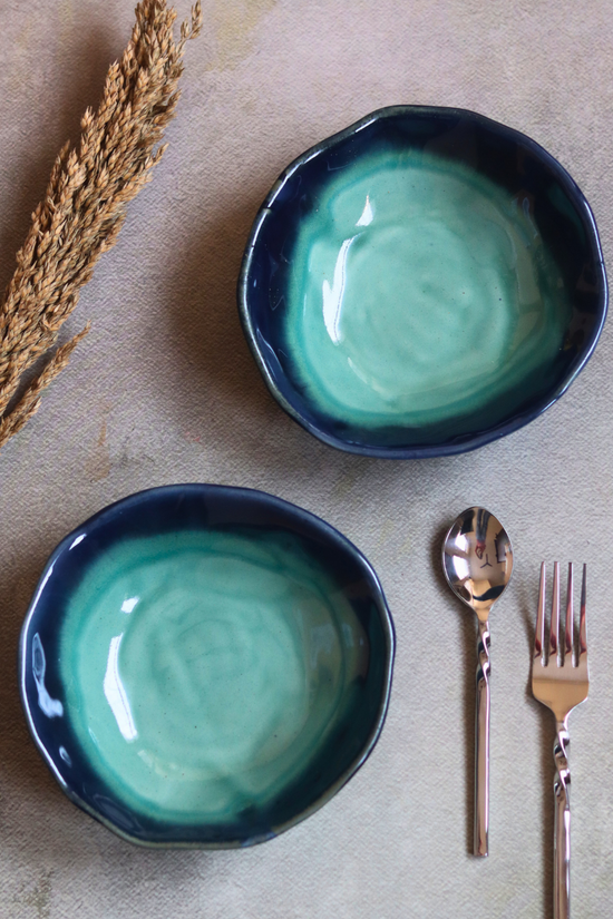 Two ceramic teal bowls with cutleries