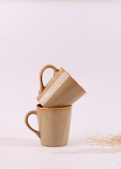 Ceramic cream coffee mugs on each other