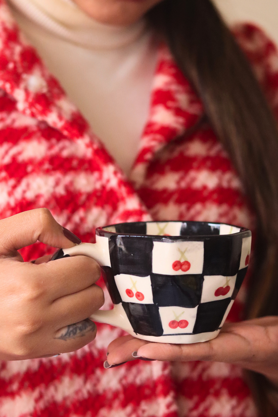 Ceramic black & white cherry coffee mug in hand 