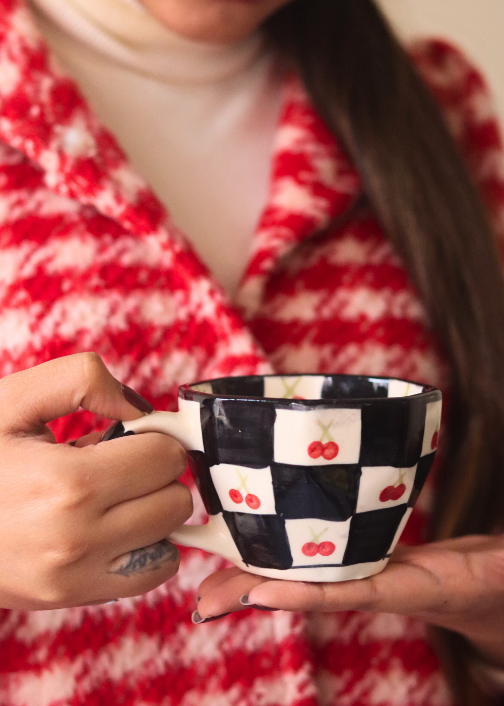 Ceramic black & white cherry coffee mug in hand 