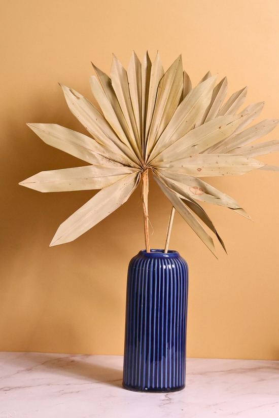 Dried palm bunch in blue vase