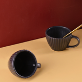 Two black spoon with a spoon and coffee bean
