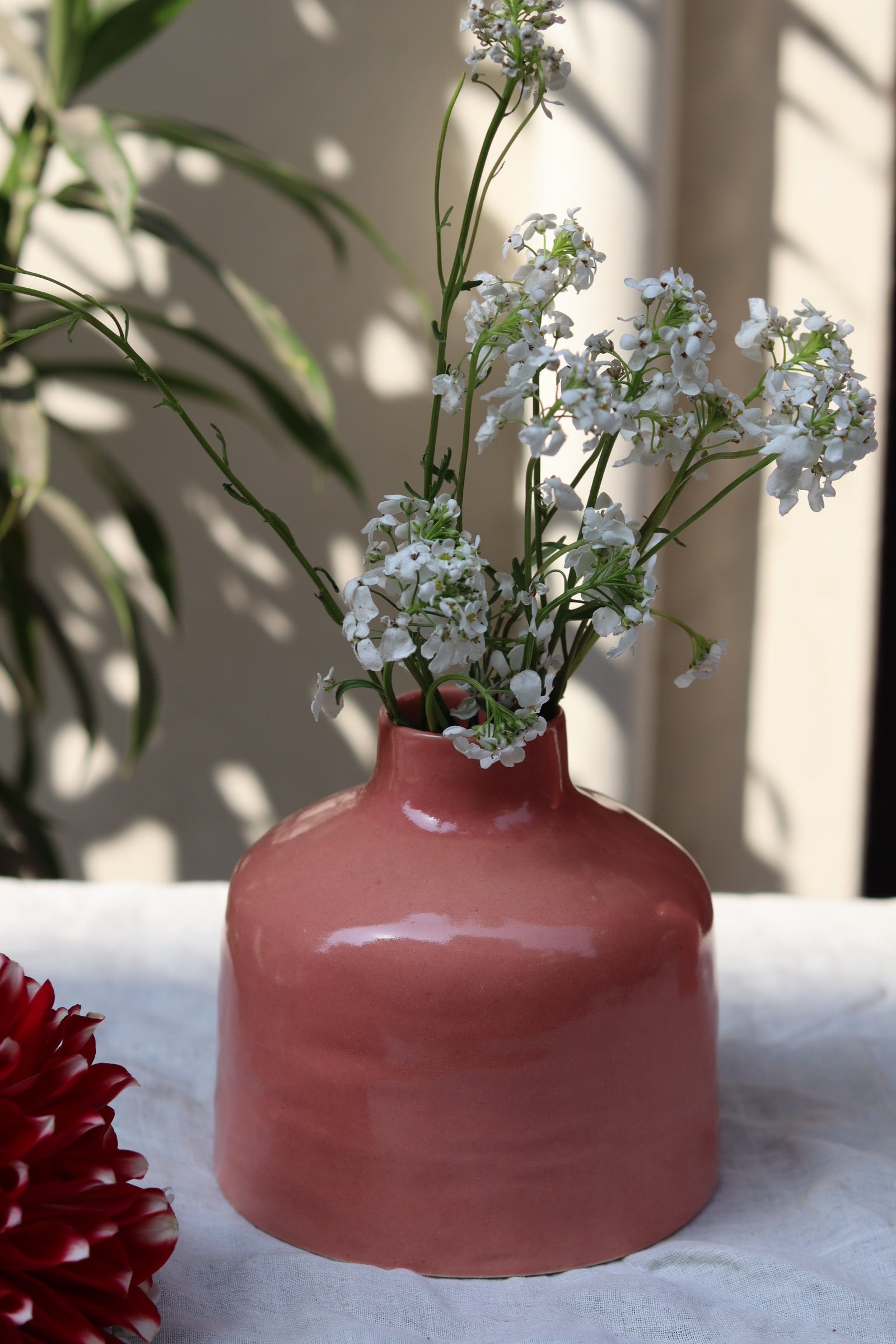 Ceramic pink flower vase with white flowers