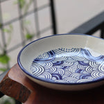 White & blue wavy pasta plate on wooden surface
