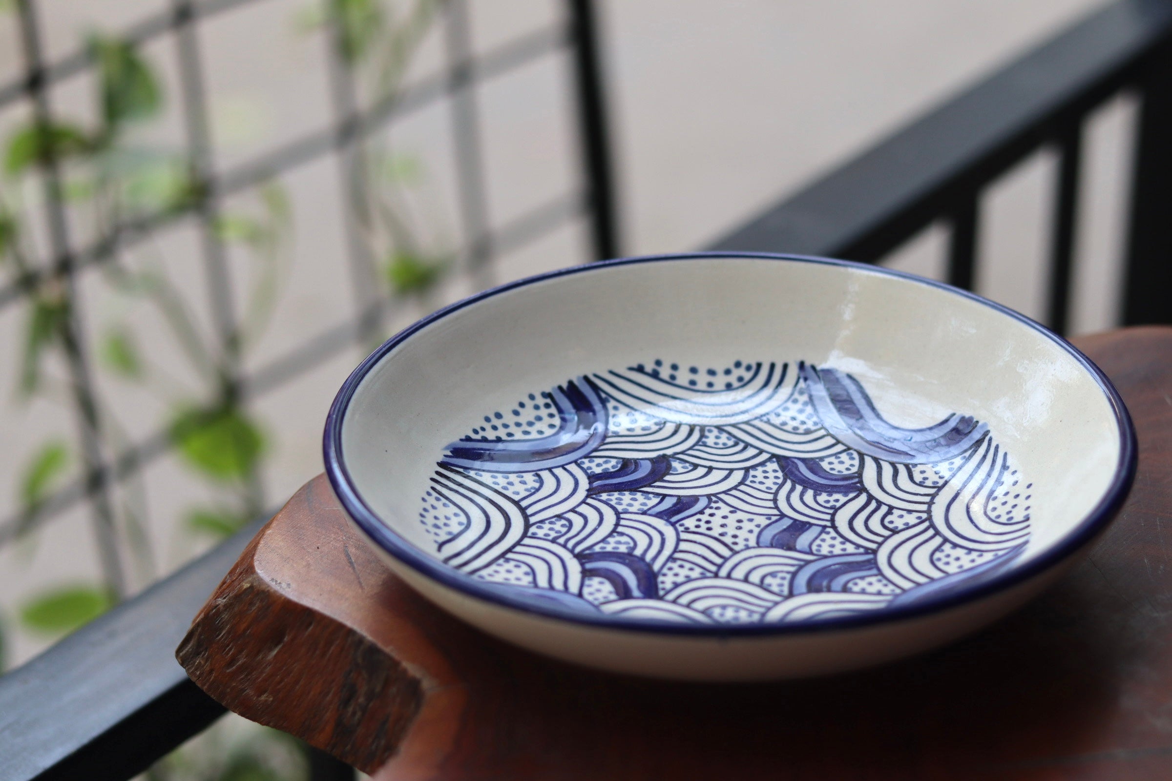 White & blue wavy pasta plate on wooden surface