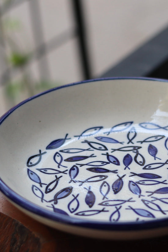 Ceramic fish pasta plate on wooden surface