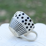 White and black coffee mug on a white surface