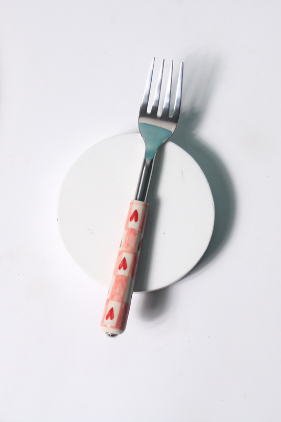 Chequered heart fork on white surface