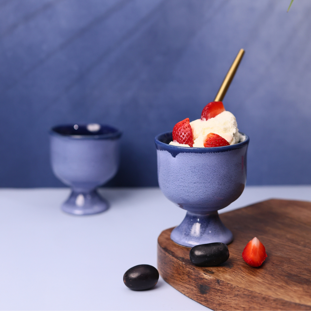 Blue icecream goblet with icecream & strawberries on it