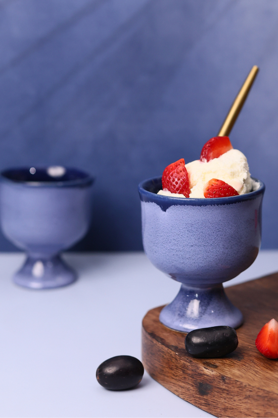 Blue icecream goblet with icecream & strawberries on it