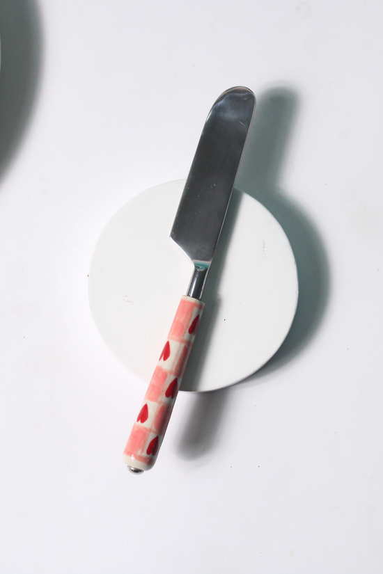 Chequered heart knife on white surface