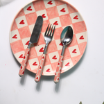 Chequered heart cutlery on plate