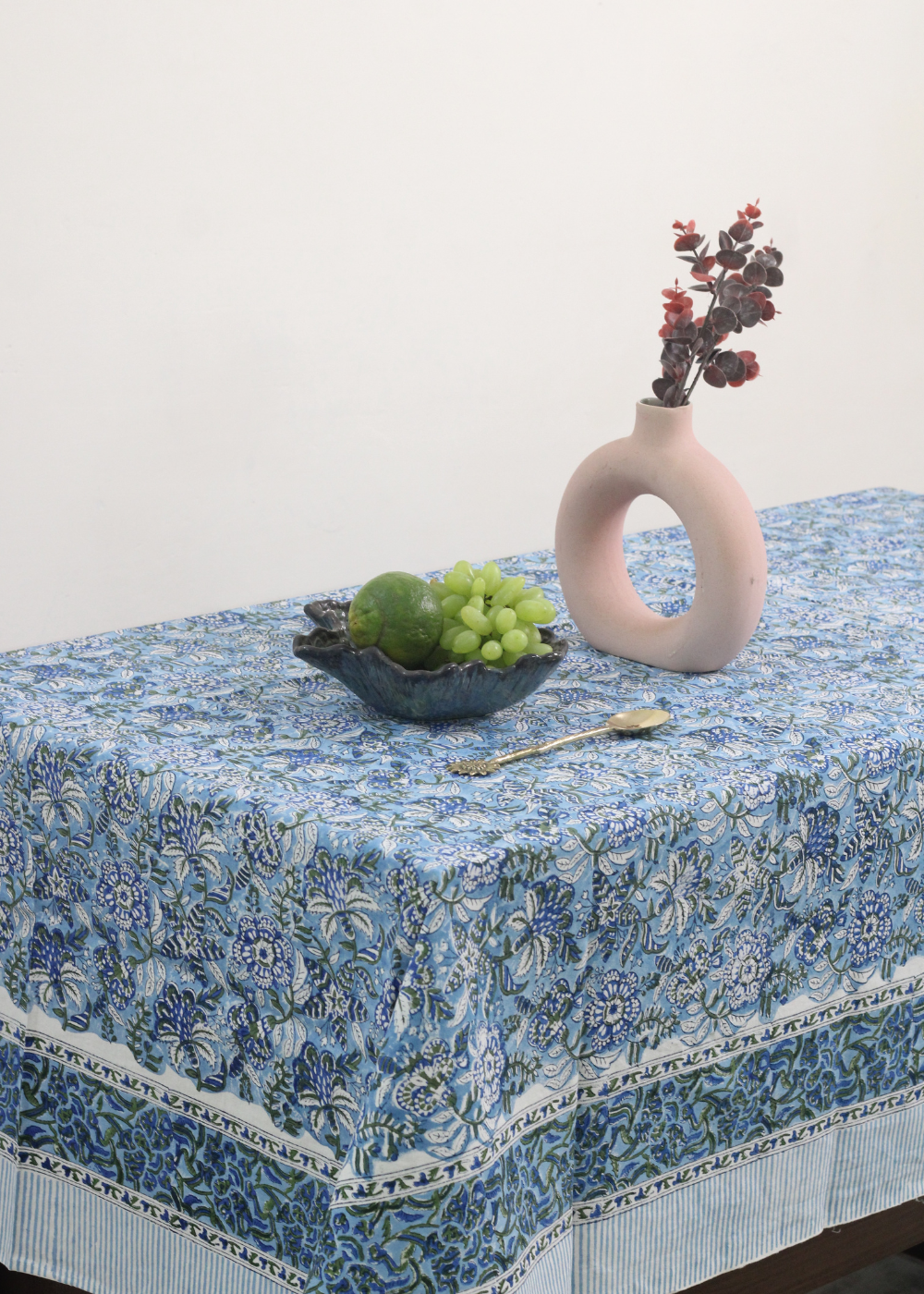 Blue floral table cloth fruits and vases