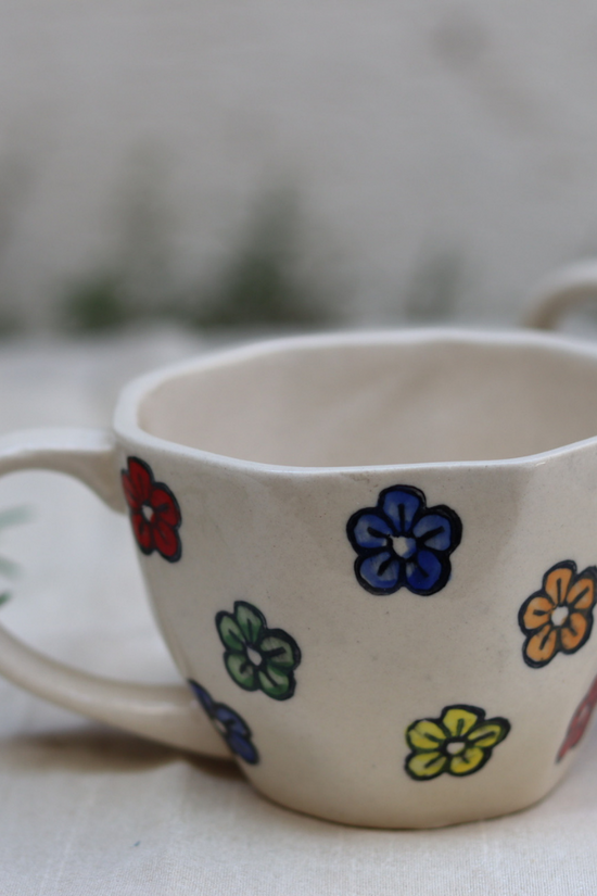 White coffee mug with flower designs on it 
