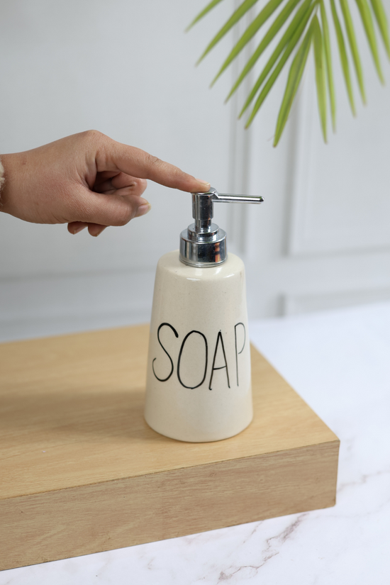 Handmade ceramic soap dispenser in hand