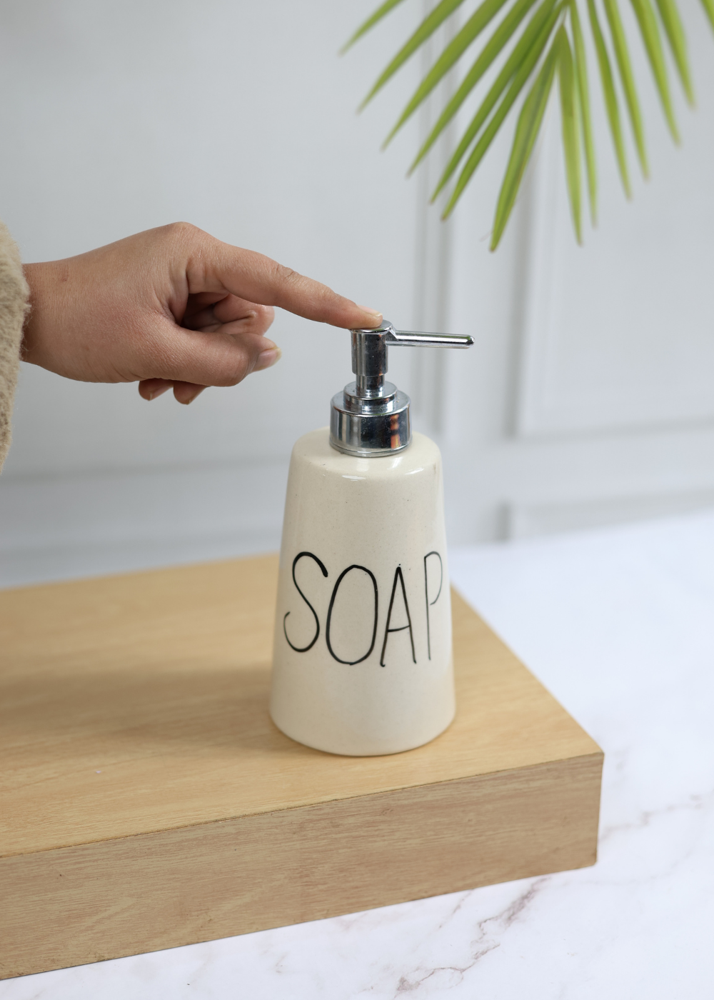 Handmade ceramic soap dispenser in hand