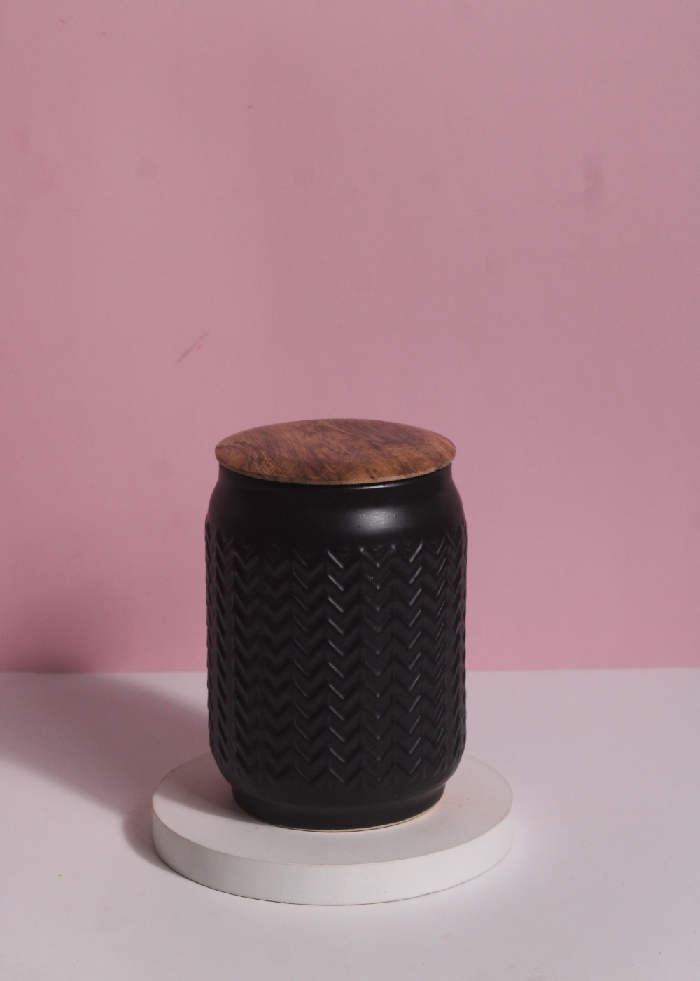 Black storage jar on white surface