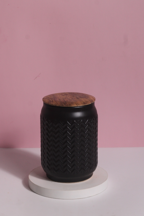 Black storage jar on white surface