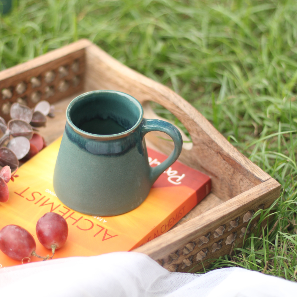Auro green tea cup on a book in a garden