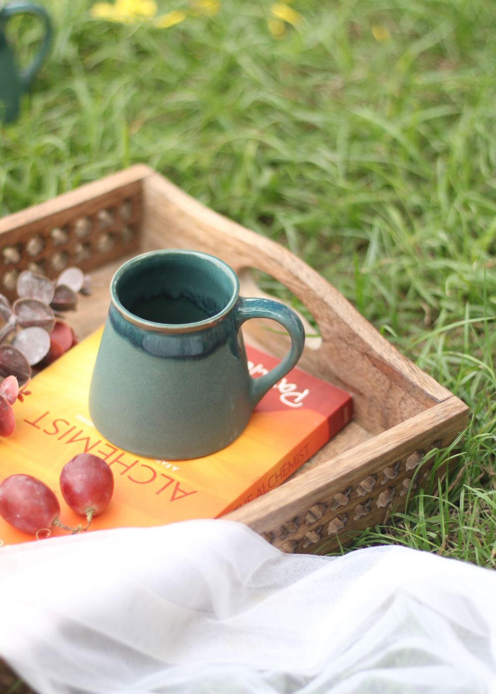 Auro green tea cup on a book in a garden