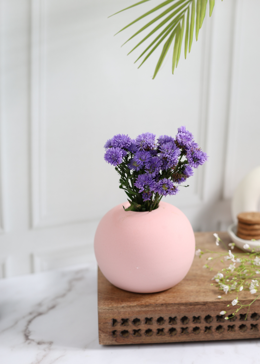 Pink color planter with lavender flowers on a wooden surface