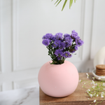 Pink color planter with lavender flowers on a wooden surface