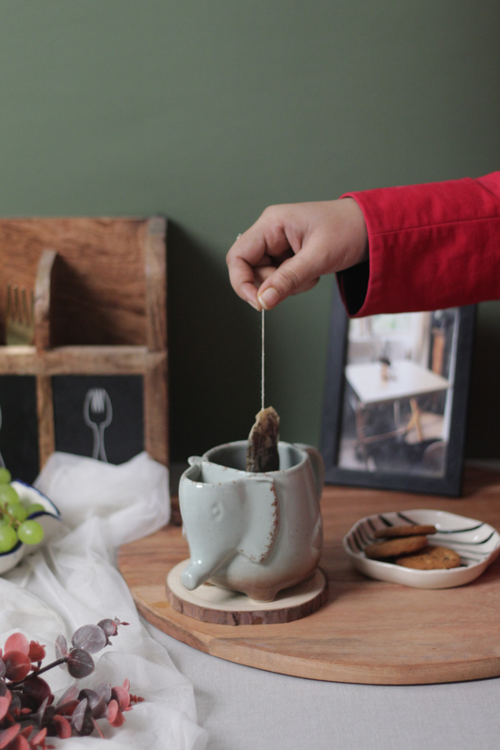 Ele mug with tea bag in hand