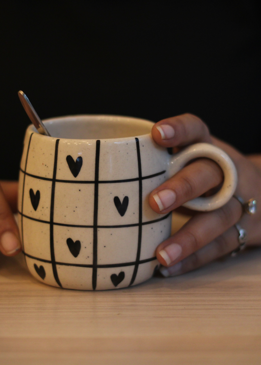 Black heart coffee mug in hand