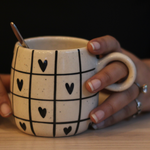 Black heart coffee mug in hand