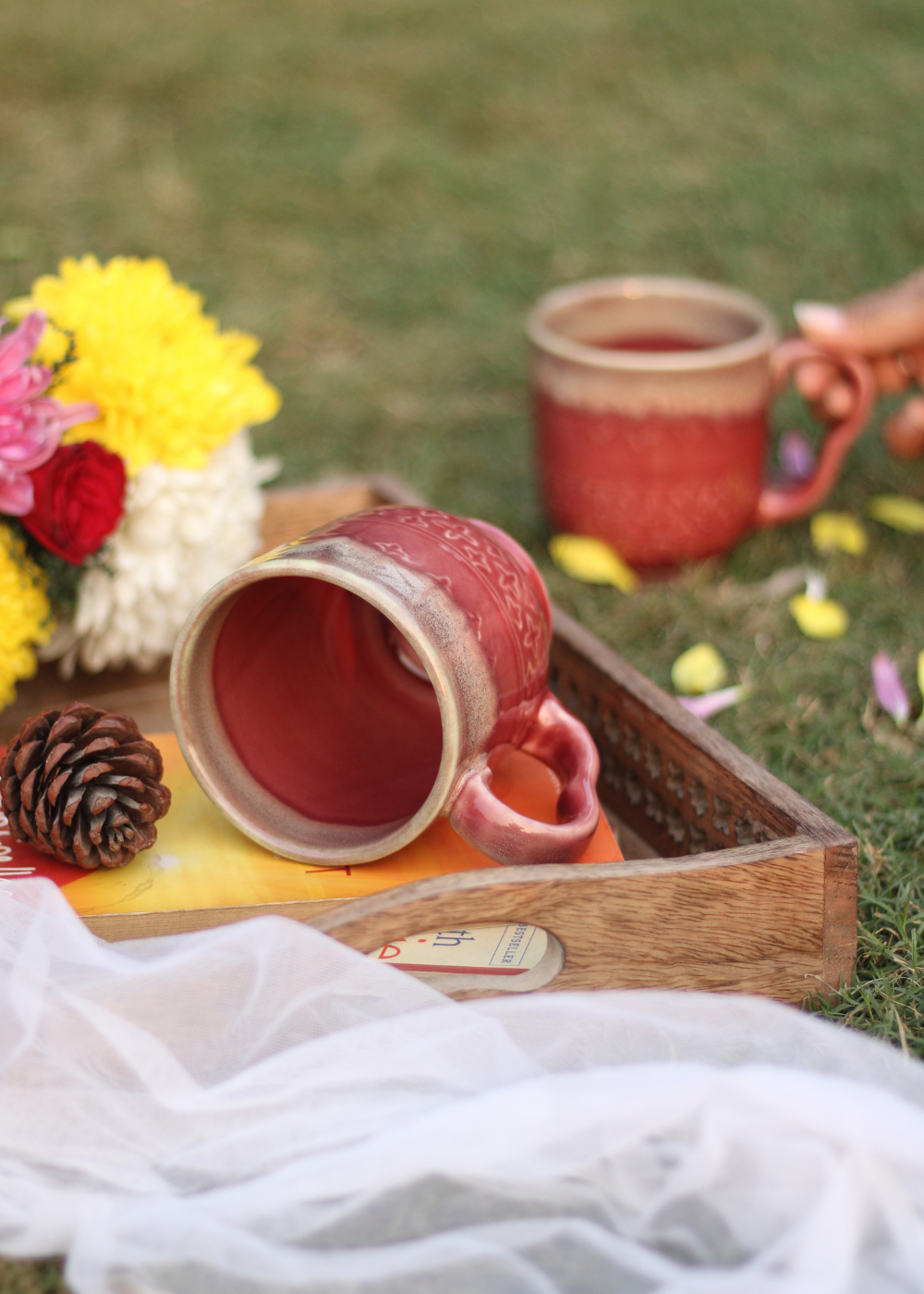 Coffee mug laying on the surface with flowers