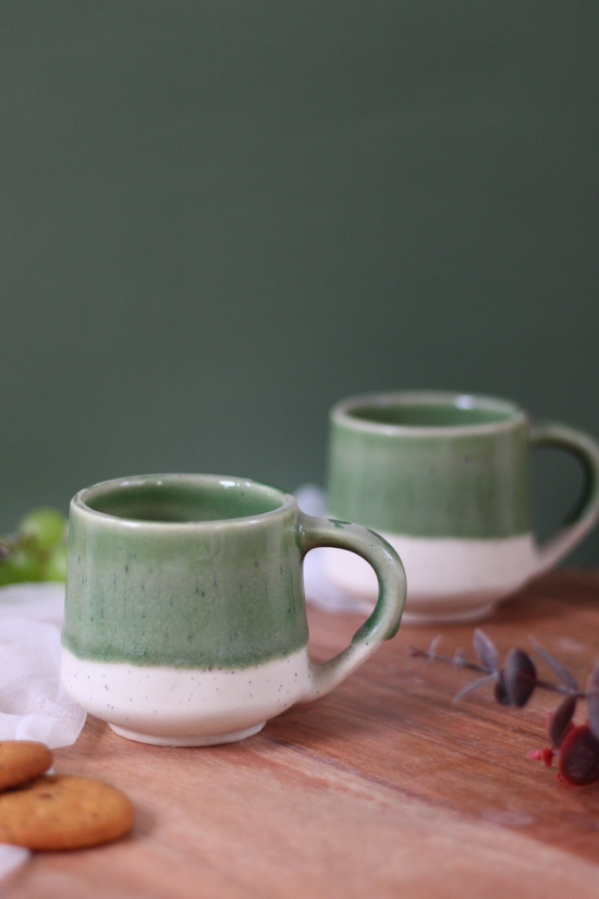 Green & white chai cup on wooden surface
