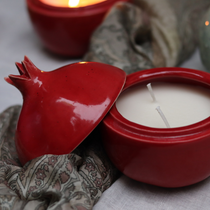Anar shaped candle on a cloth with open lid 